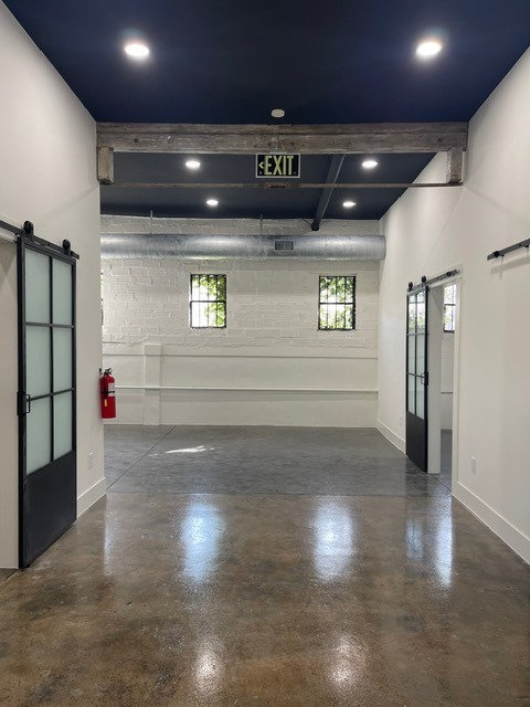 Retail space painting with polished concrete and barn doors Houston TX